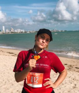 Woman poses with medal for completing 5k