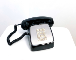 Black telephone and receiver against white background