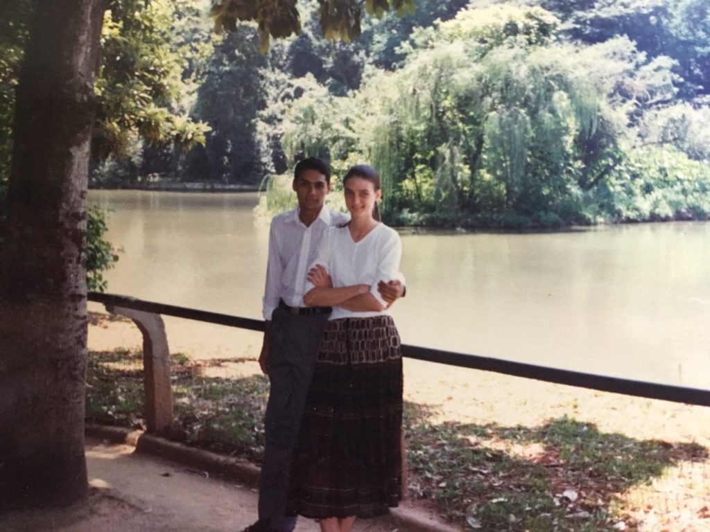 Young couple from the 90s in foreground lake behind them