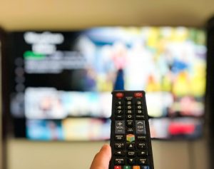 Control and TV displaying Netflix